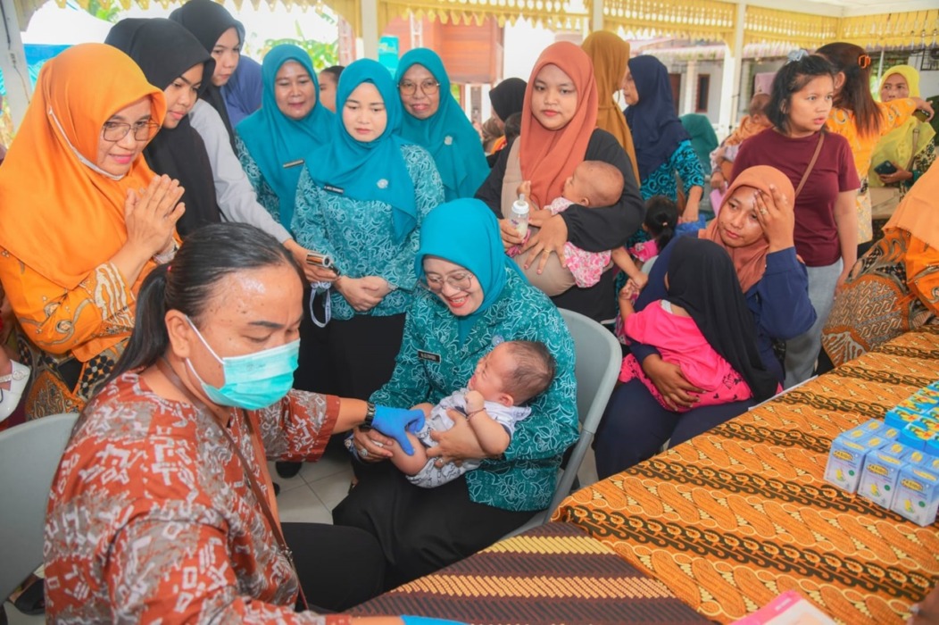 PEKAN IMUNISASI: Ketua TP PKK Kabupaten Batubara yang diwakili Staf Ahli TP PKK, Ny Leli Syafrizal, menghadiri kegiatan Sepekan Mengejar Imunisasi (PENARI) dalam rangka Pekan Imunisasi Dunia (PID) di Kantor Camat Airputih, Indrapura, Kecamatan Airputih, Jumat (10/4).(Komimfo.Batubara).