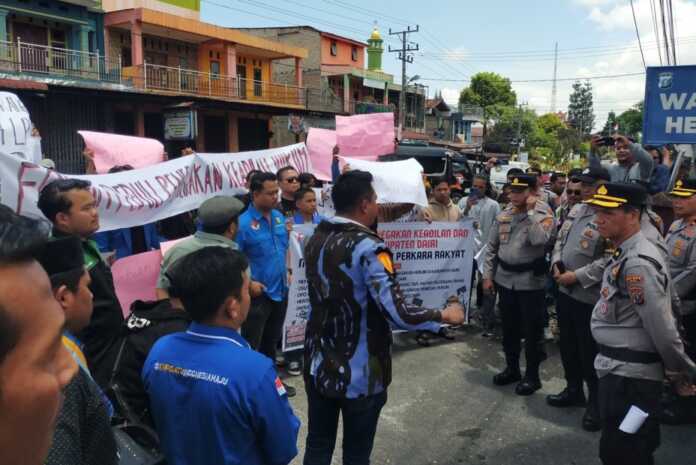 UNJUKRASA: Puluhan massa OKP tergabung dalam Forum Peduli Penegakan Keadilan dan Hukum Kabupaten Dairi, unjukrasa di Polres Dairi, Senin (13/4).RUDY SITANGGANG/SUMUT POS.