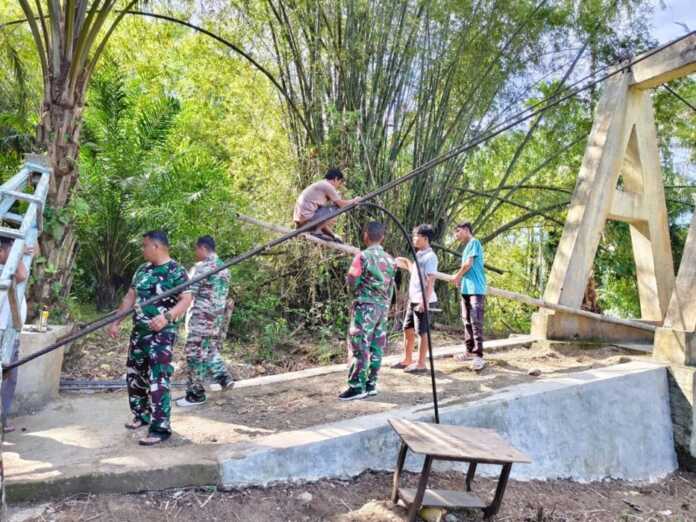 PEMBANGUNAN JEMBATAN: Prajurit TNI saat membangun jembatan gantung di Desa Parupuk Julu, Kecamatan Padangbolak Julu, Kabupaten Paluta. (Istimewa/Sumut Pos)