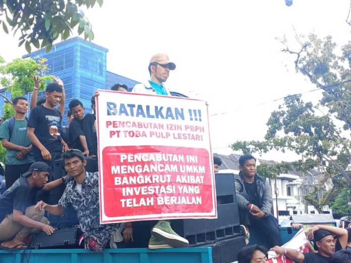 BENTANG SPANDUK: Seorang masa aksi membentangkan spanduk berisi pencabutan izin PBPH PT.TPL mengancam UMKM dan investasi yang sedang berjalan, yang ditunjukan di depan Kantor Gubernur Sumatera Utara, Jumat (18/4/2026). Foto : Ihsan Syahreza BENTANG SPANDUK: Seorang masa aksi membentangkan spanduk berisi pencabutan izin PBPH PT.TPL mengancam UMKM dan investasi yang sedang berjalan, yang ditunjukan di depan Kantor Gubernur Sumatera Utara, Jumat (18/4/2026). Foto : Ihsan Syahreza