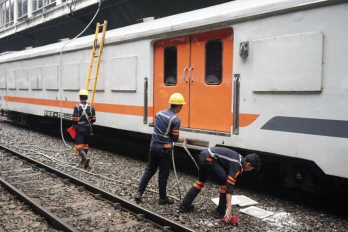 KAI Divre I Sumut BERSIHKAN: Petugas kereta api saat membersihkan gerbong kereta api penumpang. Pencucian kereta rutin dilakukan saat rangkaian berada dalam kondisi stabling atau berhenti di stasiun terminus.
