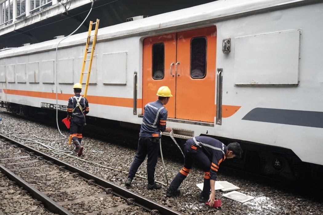 BERSIHKAN: Petugas kereta api saat membersihkan gerbong kereta api penumpang. Pencucian kereta rutin dilakukan saat rangkaian berada dalam kondisi stabling atau berhenti di stasiun terminus.