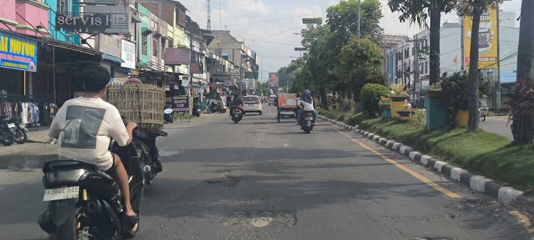 BERLUBANG: Jalan berlubang dari proyek tambal sulam di Jalan Tengku Amir Hamzah Binjai yang tak kunjung diaspal usai dilakukan potong dan tidak diberi rambu penanda.(Teddy Akbari/Sumut Pos)
