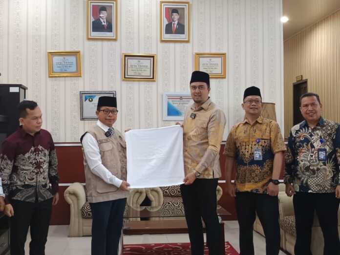 Perumda Tirtanadi SIMBOLIS: Dirut Perumda Tirtanadi Ardian Surbakti menyerahkan 5.974 handuk secara simbolis kepada Kepala Kantor Wilayah Kementerian Haji dan Umrah Provinsi Sumatera Utara, Dr. H. Zulkifli Sitorus di Gedung Asrama Haji Medan, Jumat (17/4).(ISTIMEWA)