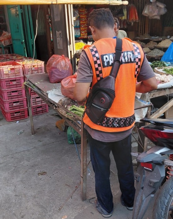 PAJAK: Jukir mengenakan rompi oranye bertuliskan ‘Parkir’ terlihat berada di area Pajak Inpres saat beraktivitas di sekitar lapak pedagang, terkait keluhan warga mengenai pelayanan parkir, Sabtu (18/04/2026). (Azan purba/ sumut pos).