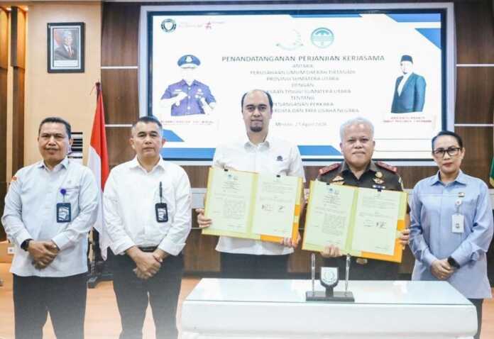 KERJA SAMA: Dirut Perumda Tirtanadi Ardian Surbakti bersama Kepala Kejatisu DR Harli Siregar SH MHum menunjukkan MoU yang mereka tanda tangani di Aula Lantai III Kantor Kejati Sumut, Jalan AH Nasution, Medan, Selasa (21/4).(DOK PERUMDA TIRTANADI SUMUT)