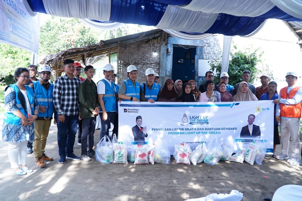 FOTO BERSAMA: Masyarakat foto bersama saat menerima bantuan sembako serta penyalaan listrik gratis dari PLN UP3 Pematangsiantar.
