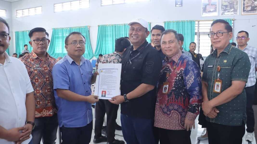 SERAHKAN: Ketua Satgas Percepatan program MBG juga Wabup Dairi, Wahyu Daniel Sagala, menyerahkan SLHS kepada salahsatu pemilik dapur MBG. (RUDY SITANGGANG/SUMUT POS)