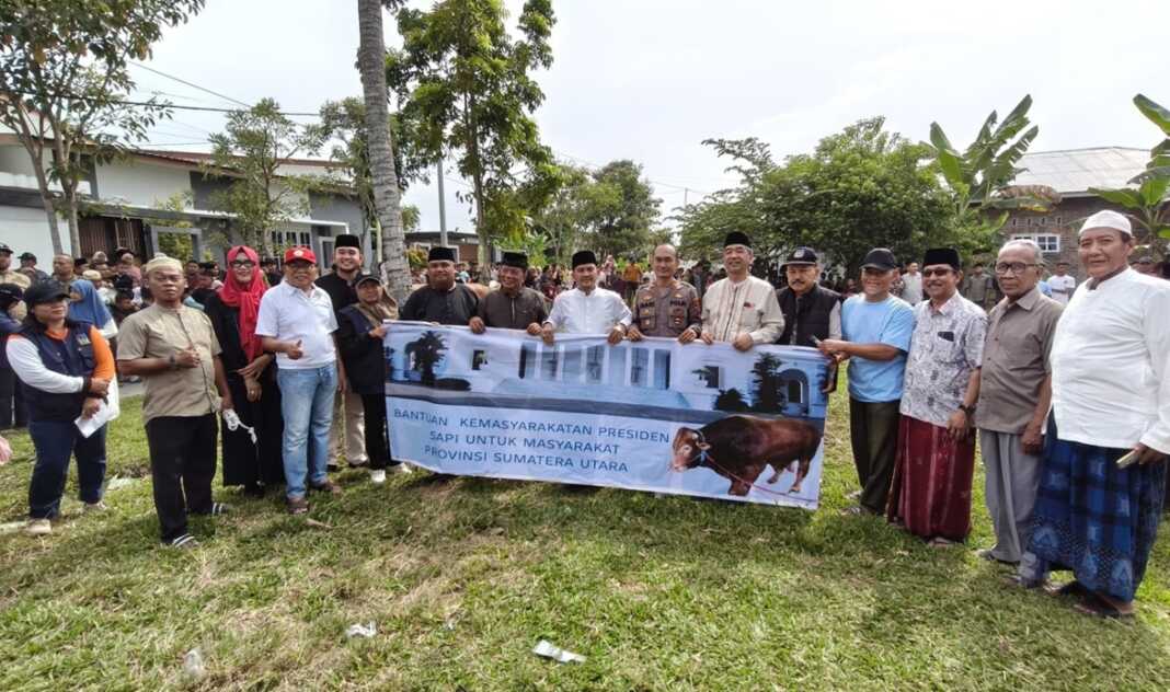 BERSAMA MANTAN: Wali Kota Tebingtinggi Iman Irdian Saragih bersama mantan Wakil Wali Kota Tebingtinggi, Oki Doni Siregar,  Sekdako Tebingtinggi,unsur Forkopimda, tokoh masyarakat dan warga saat menghadiri penyerahan bantuan kemasyarakatan Presiden berupa sapi kurban untuk masyarakat Sumatera Utara di Kecamatan Rambutan, Rabu (27/5/2026) Azan Purba /sumutpos.