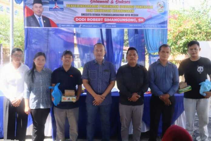 FOTO BERSAMA: Anggota DPRD Medan dari Fraksi Partai Demokrat Dodi Robert Simangunsong foto bersama peserta sosialisasi Pembinaan Ideologi Pancasila dan Wawasan Kebangsaan di Jalan Pulau Harapan, Medan Kota, Sabtu (30/5/2026).