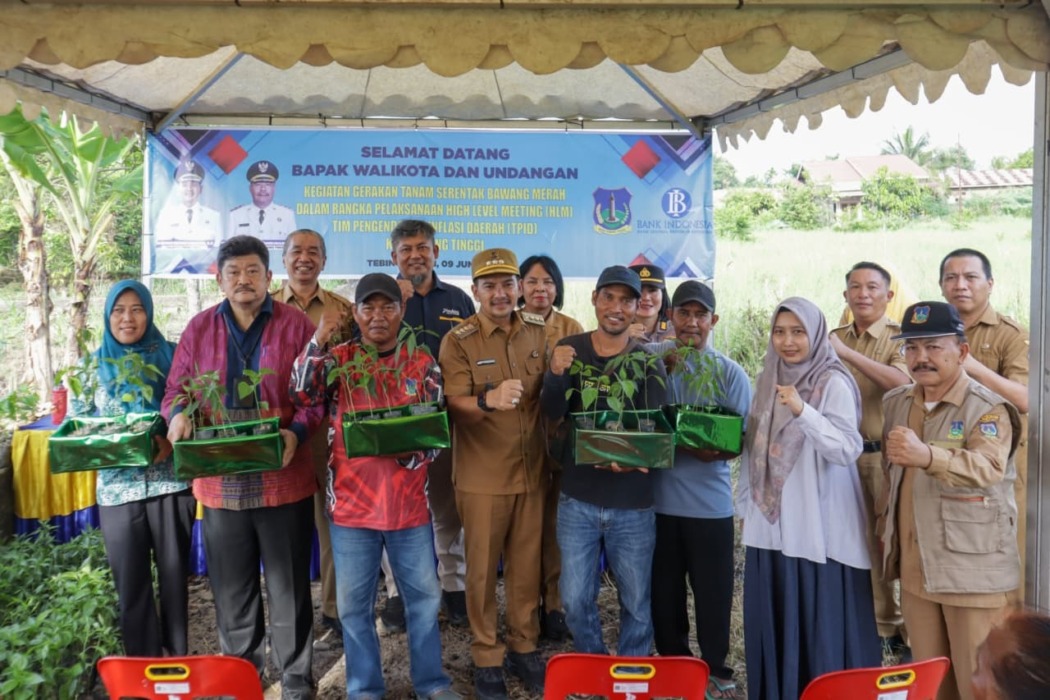 TUNJUKKAN BIBIT: Wali Kota Tebingtinggi H Iman Irdian Saragih bersama perwakilan Bank Indonesia, unsur gorkopimda, kepala OPD, dan kelompok tani menunjukkan bibit cabai merah usai penyerahan bantuan stimulan pada kegiatan Gerakan Tanam Serentak Bawang Merah yang dirangkaikan dengan High Level Meeting (HLM) TPID di Kelurahan Mekarsentosa, Kecamatan Rambutan, Selasa  (9/6/2026).(Azan Purba /sumutpos).