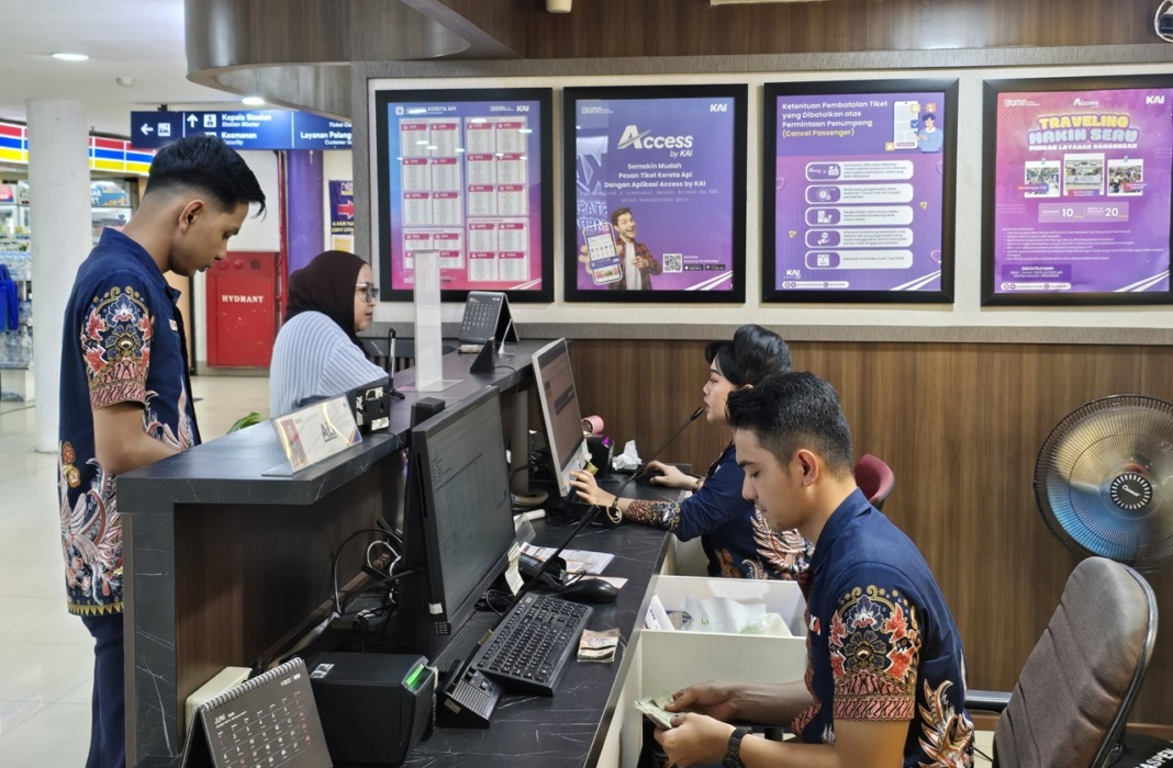 LAYANI: Pegawai PT Kereta Api Indonesia (Persero) Divisi Regional I Sumatera Utara saat melayani calon penumpang kereta api. Saat libur Tahun Baru Islam, KAI Sumut layani 14.967 pelanggan.