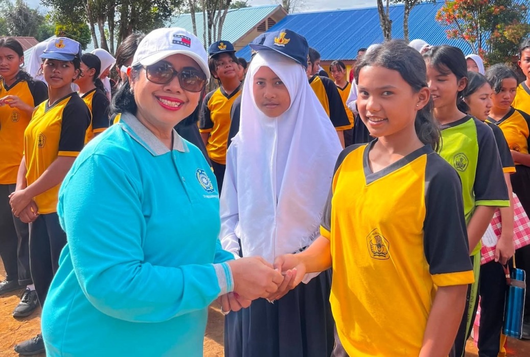 SERAHKAN: Ketua TP PKK Rita Puspita boru Situmorang serahkan tablet tambah darah kepada pelajar putri saat canangkan gerakan aksi bergizi di SMPN 2 Siempat Nempu Hulu, Senin (15/6).(Komimfo Dairi).