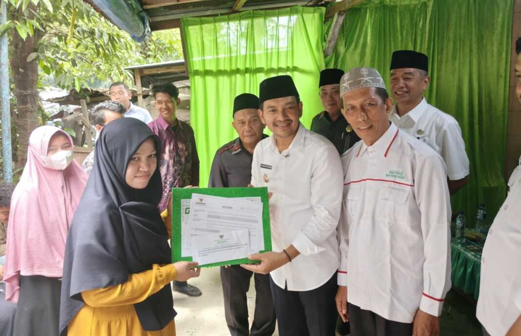 BANTUAN: Wali Kota Tebing Tinggi Iman Irdian Saragih, menyerahkan secara simbolis bantuan modal usaha dana bergulir kepada pelaku UMKM dalam kegiatan penyaluran beasiswa dan bantuan usaha yang digelar BAZNAS Kota Tebingtinggi di Kelurahan Brohol. (Azan purba / sumutpos).
