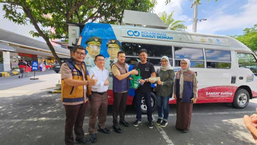 HADIAH: Kepala Bapenda Kota Medan M. Agha Novrian, memberikan hadiah kepada warga yang membayar pajak kendaraan bermotor.