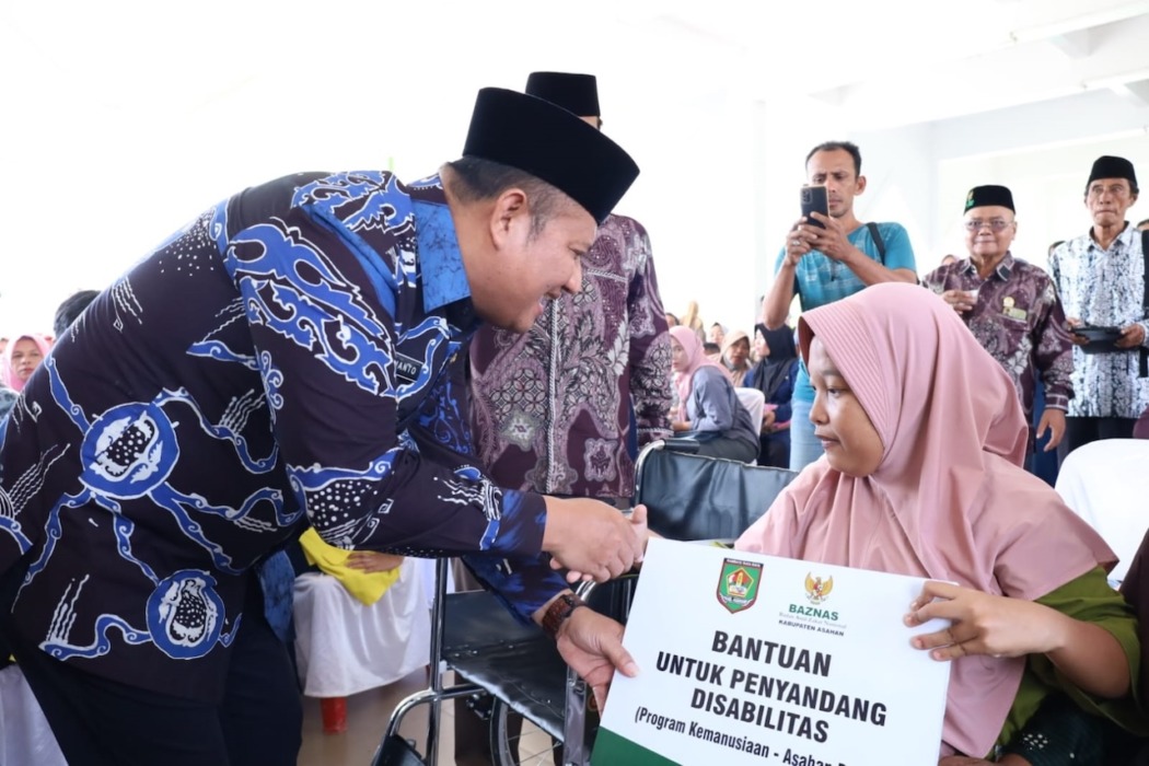 SERAHKAN: Wakil Bupati Asahan Rianto menyerahkan bantuan zakat, infak, dan sedekah (ZIS). 