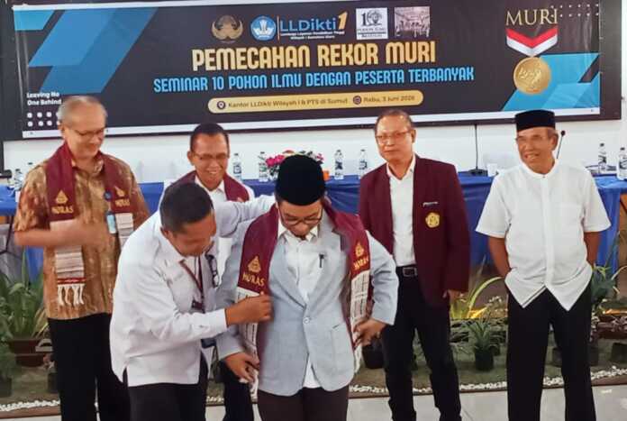 CENDERA MATA: Prof. Dr. Akrim Lubis, M.Pd menerima pengalungan ulos dari kepala bagian umum LLDikti Wilayah I. (Deddi Mulia Purba/Sumut Pos)