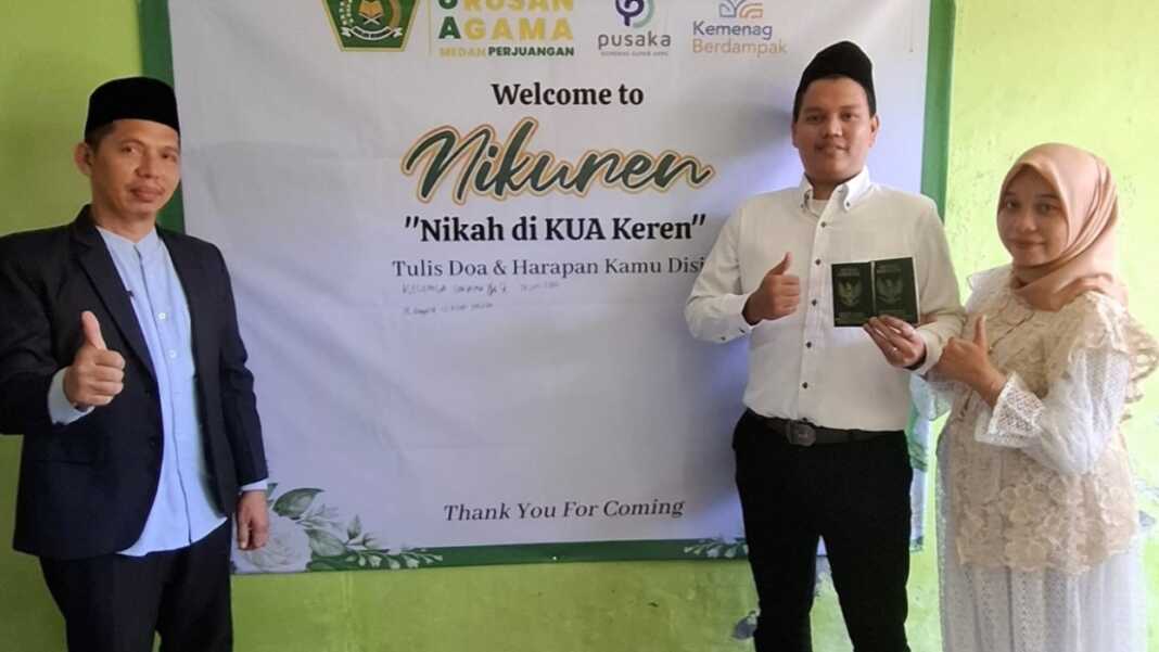 FOTO BERSAMA: Kepala KUA Kecamatan Medan Perjuangan, H Ramlan (kiri) berfoto bersama pengantin yang baru nikah di Kantor KUA kecamatan Medan Perjuangan, Jalan Pendidikan dengan menuliskan impuan di papan wedding wish board.(Tomi Sanjaya Lubis/Sumut Pos)