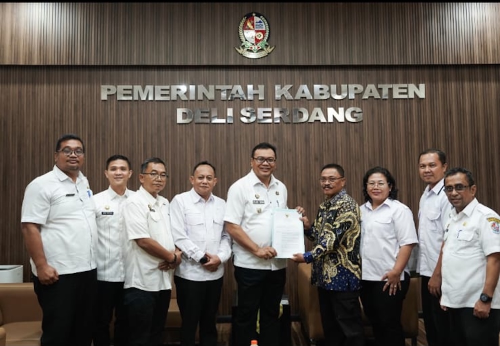 SERAHKAN SK: Bupati Deliserdang, Asri Ludin Tambunan menyerahkan surat keputusan pengangkatan Nasib Solichin (baju batik) sebagai Ketua FKDM Kabupaten Deliserdang yang baru.