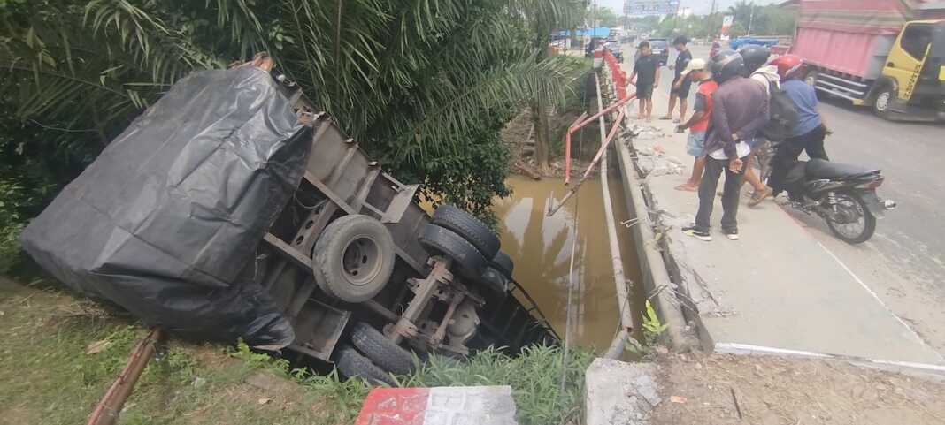 KECELAKAAN TUNGGAL: Sebuah truk fuso kecelakaan tunggal, terjung ke sungai di kawasan Titi Kembar Marbau, Kotapinang, Labusel, Senin (20/7) (fajar)
