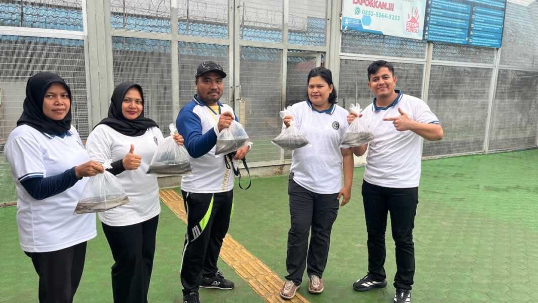 FOTO BERSAMA: Kalapas Binjai Mochamad Mukaffi bersama lainnya, menunjukkan ikan lele hasil budidaya Lapas Binjai. (Humas Lapas Binjai/Sumut Pos)