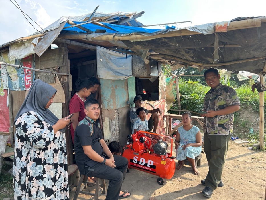 TERIMA BANTUAN: Penghuni rumah kardus di bantaran Sungai Deli, Kelurahan Besar, Kecamatan Medan Labuhan saat menerima bantuan dari pemerintah setempat.