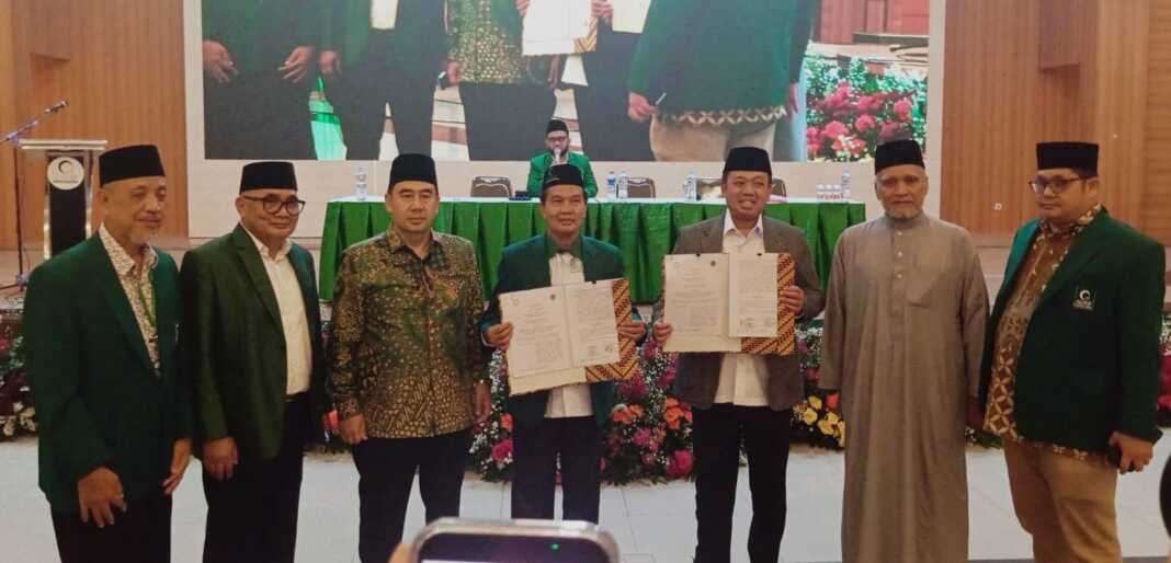KERJA SAMA: Nusron Wahid (3 kanan) dan KH Dr. Masyhuril Khamis memegang naskah kerja sama, Rabu (8/7) malam. (Istimewa/Sumut Pos)