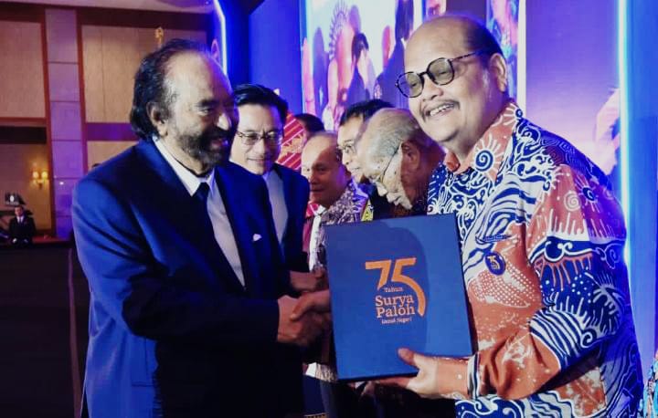 SURYAPALOHISME: Dr. H. Muhammad Isa Indrawan, M.M (kanan) menerima buku dari Surya Paloh didampingi Iskandar, S.T. (Istimewa/Sumut Pos)