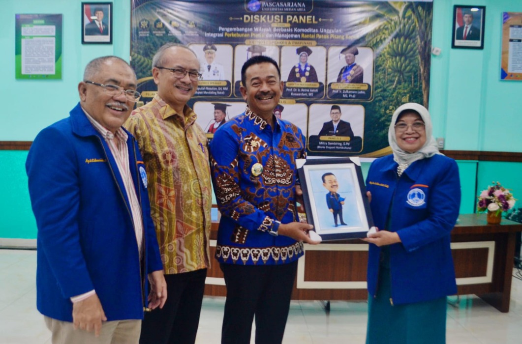 PASCASARJANA UMA: Direktur Pascasarjana UMA Prof. Dr. Ir. Retna Astuti Kuswardani, MS (kanan) menyerahkan cendera mata kepada bupati Mandailingnatal, Sabtu (25/7). (Deddi Mulia Purba/Sumut Pos)