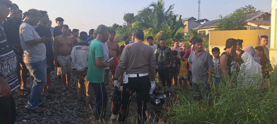 EVAKUASI: Petugas bersama warga mengevakuasi korban kecelakaan di perlintasan rel Jalan Lama, Kelurahan Sri Padang, Tebingtinggi, Sabtu (8/8) sore. (Azan purba/ Sumutpos).