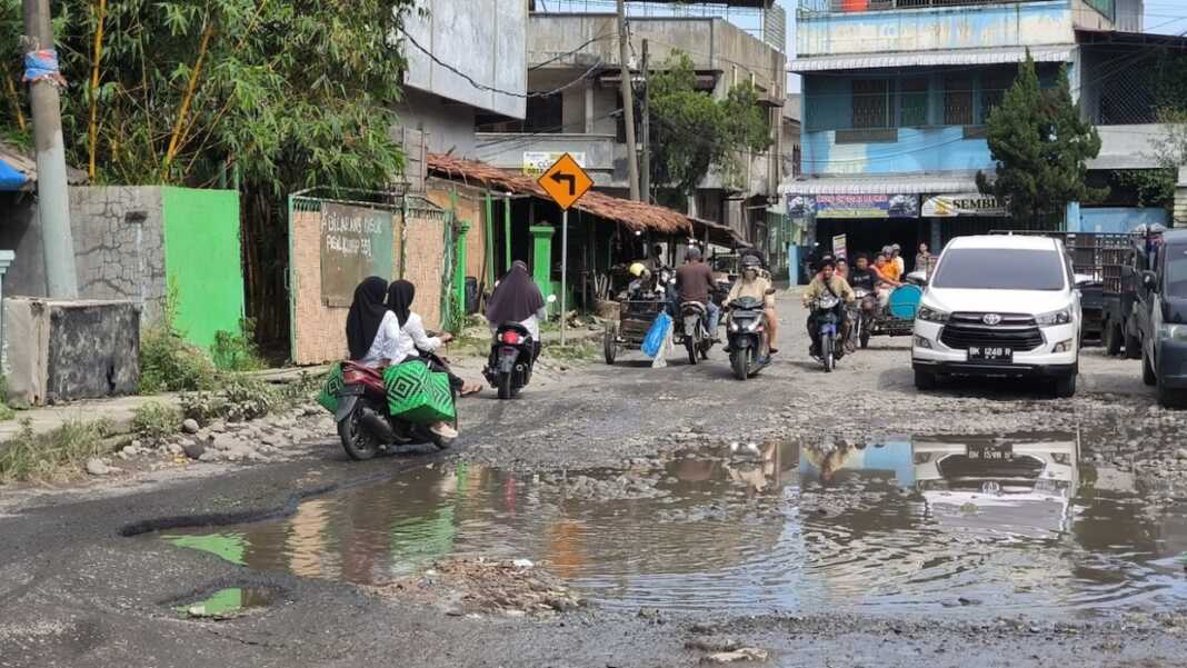 JALAN RUSAK: Kondisi jalan rusak di Jalan Wahidin Baru seputaran Pasar Tavip Binjai akan diperbaiki tahun 2026 ini pakai Dana TKD. (Teddy Akbari/Sumut Pos)