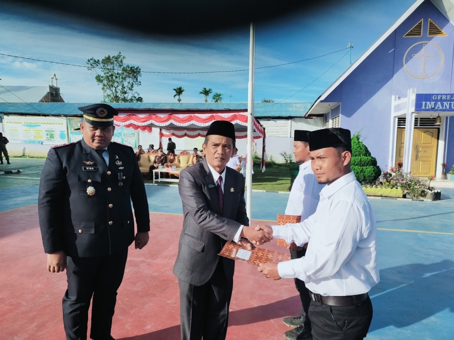 REMISI: Asisten 3 Administrasi Umum, Dapot Hasudungan Tamba bersama Kepala Rutan Kelas IIB Sidikalang, Loviga Ferdinanta Sembiring menyerahkan remisi kepada 2 WBP, Senin (17/8). RUDY SITANGGANG/SUMUT POS.