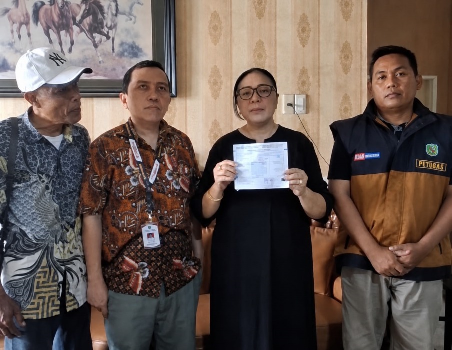 SELESAI: Warga Perumahan Menteng Indah, Medan Denai Martha Tobing menunjukkan surat data PBB miliknya yang telah disesuaikan Bapenda Kota Medan.