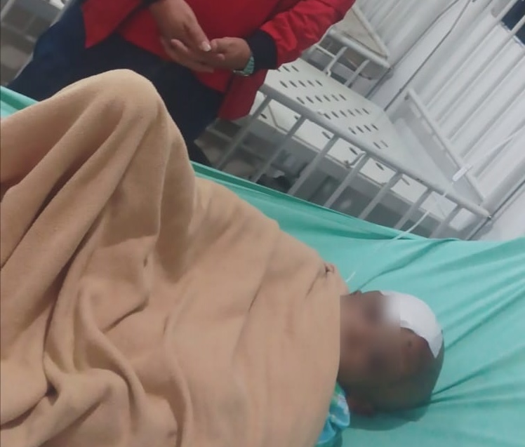 KORBAN: Ketua DPC PDIP Dairi, Resoalon Lumbangaol saat megunjungi korban AP (7) di RSUD Sidikalang, Jumat (21/8). (RUDY SITANGGANG/SUMUT POS).