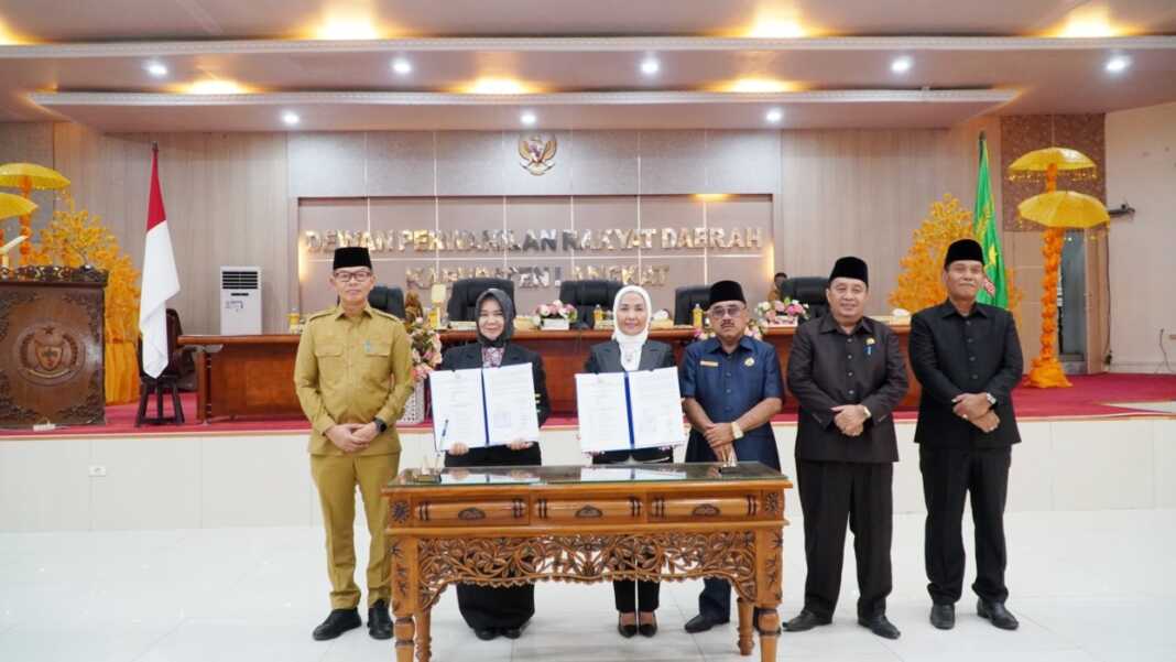 DOKUMEN: Plt Bupati Langkat, Tiorita br Surbakti saat menunjukkan dokumen usai penandatanganan bersama DPRD dalam rapat paripurna. (Diskominfo Langkat/Sumut Pos)