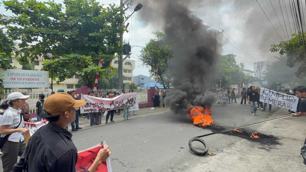 BAKAR BAN: Mahasiswa UDA membakar ban sebagai bentuk kekecewaan kepada pihak kampus. Aksi tersebut digelar di depan Biro Rektor, Jalan DR TD Pardede Medan, Jumat (28/8/2026).