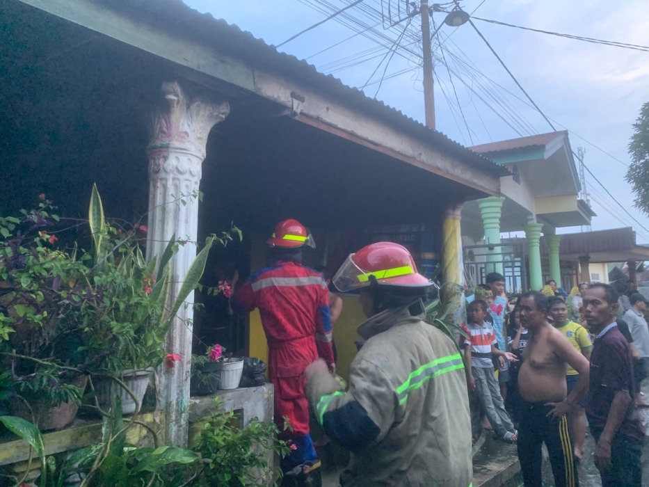 PKEBAKARAN RUMAH: Petugas pemadam kebakaran memeriksa rumah warga, di Kelurahan Tanjungmarulak, Sabtu (12/9).//Azan purba/sumutpos.