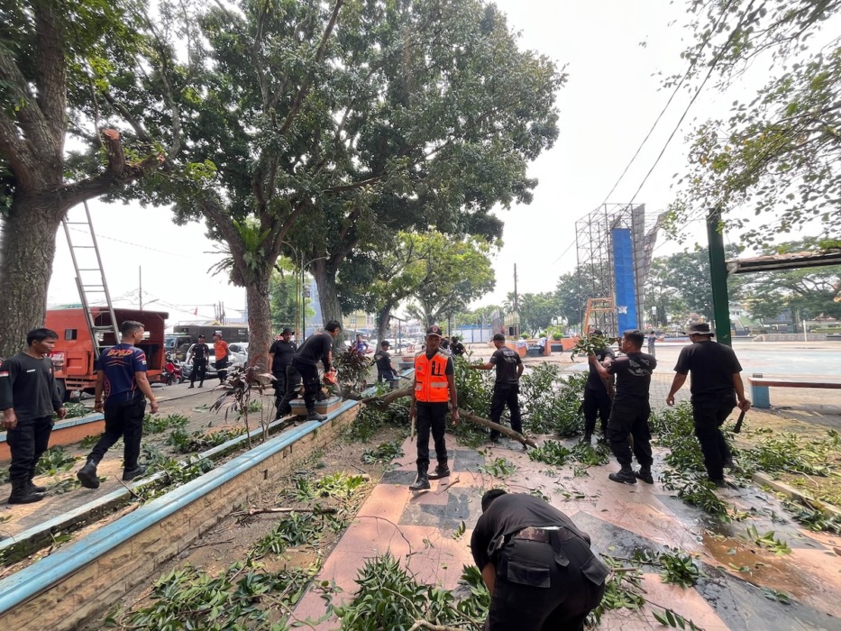 PANGKAS: BPBD Binjai melakukan pemangkasan pohon di seputaran Lapangan Merdeka. (Diskominfo Binjai/Sumut Pos)