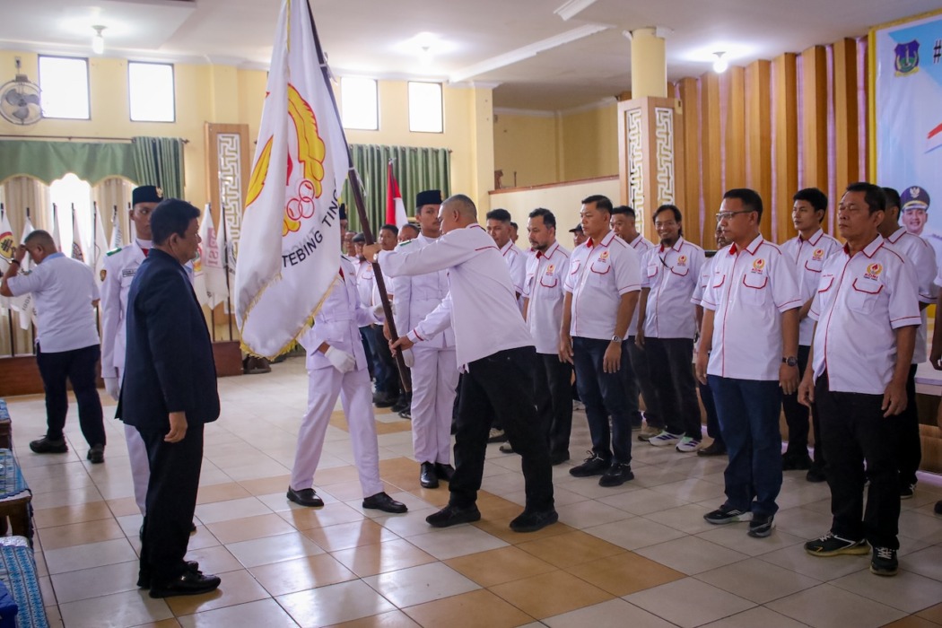 Ketua Umum KONI Sumut Kolonel TNI (Purn) Hatunggal Siregar menyerahkan pataka kepada Ketua KONI Kota Tebing Tinggi Aulia Pitra di Gedung Hj Sawiyah, Kamis (17/9). (Azan Purba/Sumut Pos).
