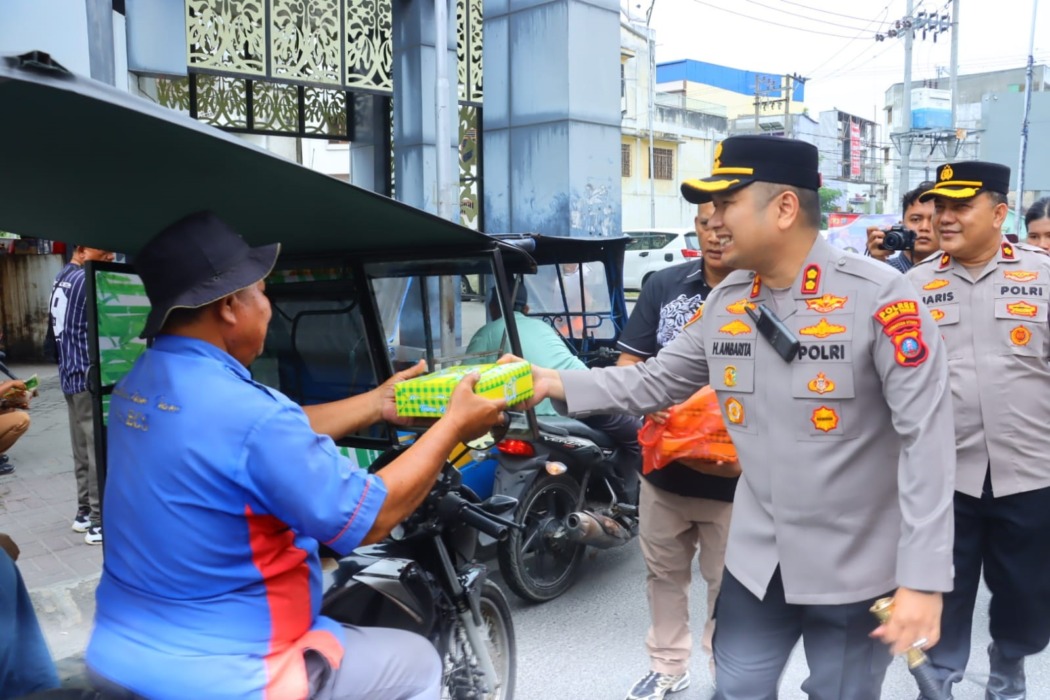 SERAHKAN MAGER: Kapolres Tebingtinggi AKBP Hotmartua Ambarita menyerahkan makanan kepada warga dalam program Mager (Makan Gratis), didampingi Wakapolres Kompol M Haris S, Jumat (25/9)///Azan Purba /Sumutpos.