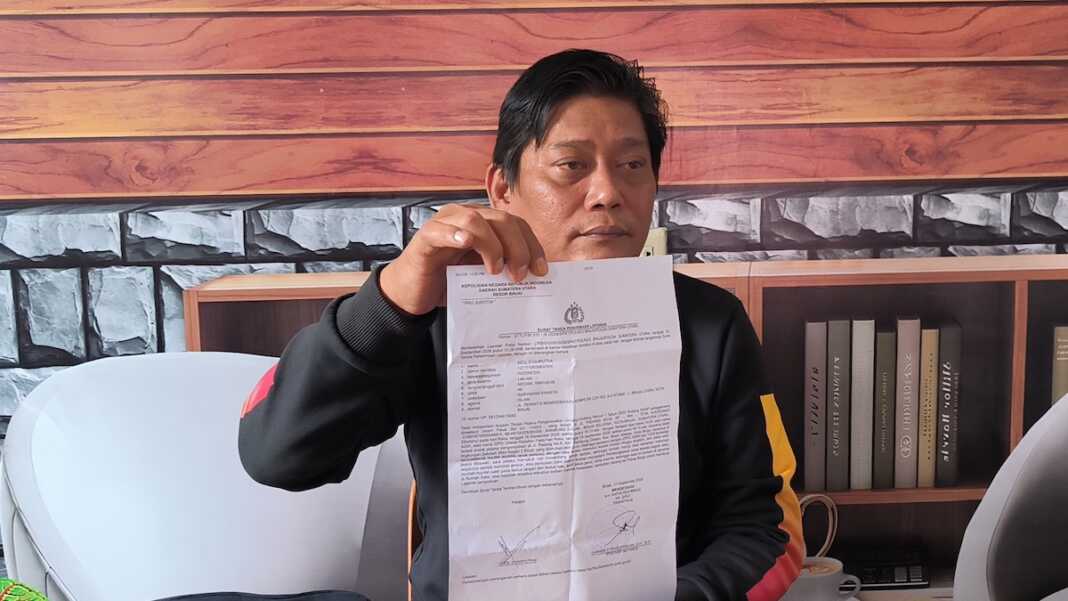 BUKTI LAPORAN: Orangtua korban menunjukkan bukti laporan polisi. (Teddy Akbari/Sumut Pos)