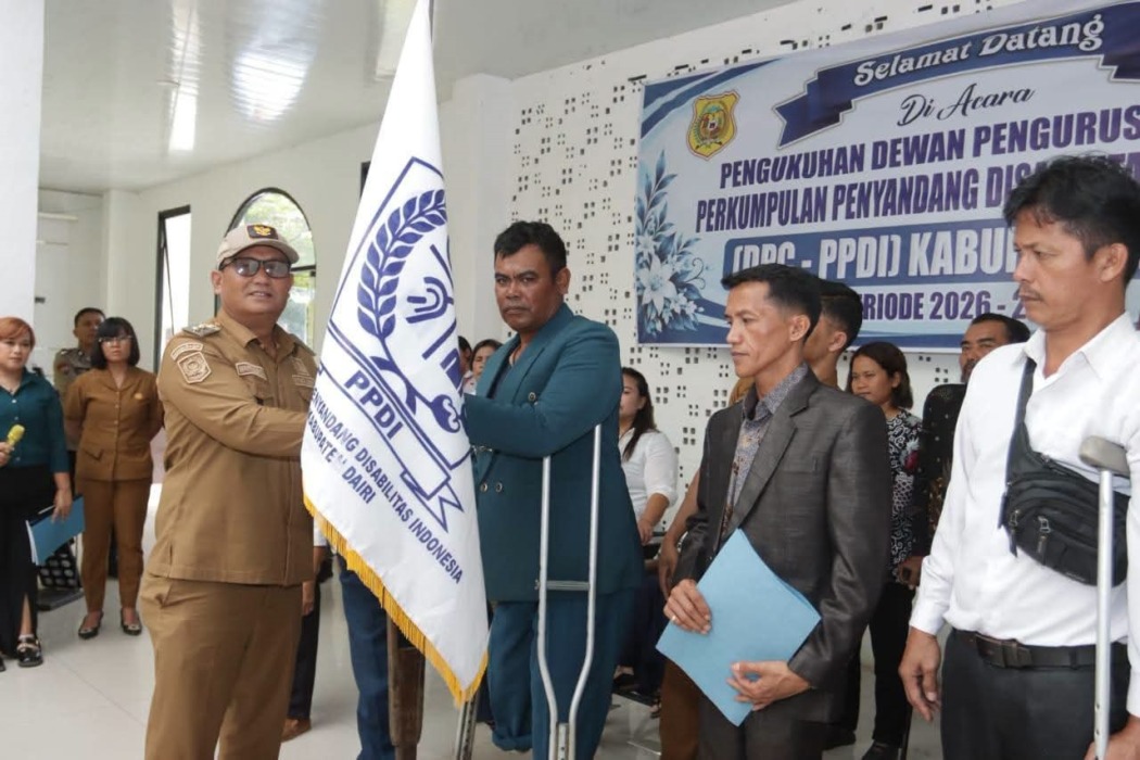 Wabup Dairi Wahyu Daniel Sagala menyerahkan pataka kepada Ketua PPDI, Raspen Capah untuk pimpin PPDI periode 2026-2031 di gedung PLUT Sidikalang, Senin (28/9).RUDY SITANGGANG/SUMUT POS.