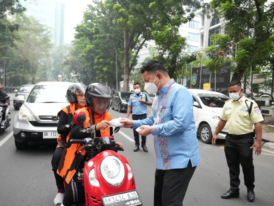 Sekretaris DPRD Sumut, Ali Sipahutar membagikan masker kepada pengendara di depan Gedung DPRD Sumut, Kamis (15/10/2026) sore. (Sekretariat DPRD Sumut).