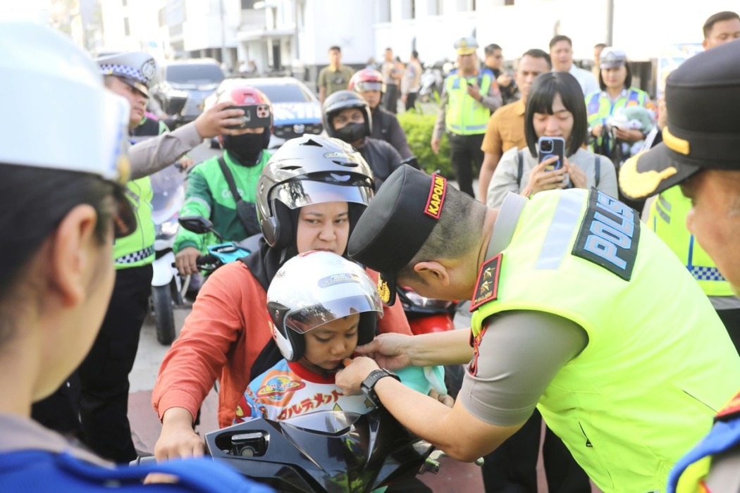 Kapoldasu Irjen Pol Sonny Irawan saat membagikan helm kepada pengendara di Jalan Lapangan Merdeka, Medan, Senin (19/10). Istimewa/Sumut Pos.