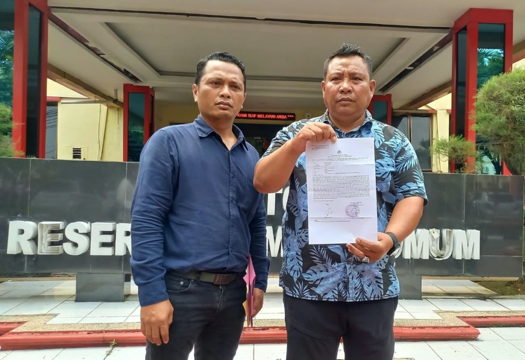 Mahasiswa S-2 UDA, David Eka Putra (kanan) didampingi Koordinator AKDA, Liston Hutajulu (kiri), menunjukkan bukti laporannya ke Polda Sumut, Rabu (21/10/2026).