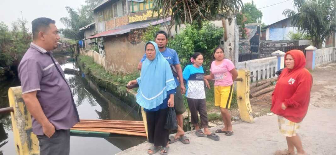 BERTANYA: Zulham Efendi saat bertanya dengan warga tentang kemunculan buaya di Perairan Siombak.