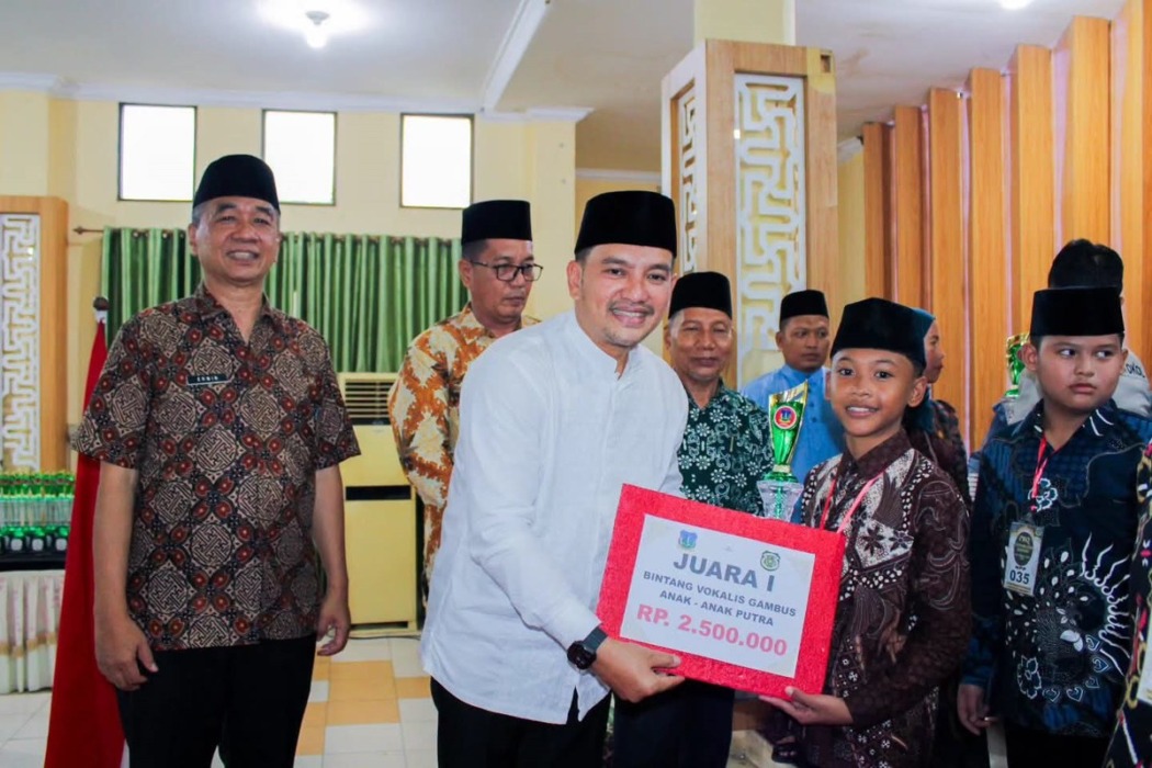 Wali Kota Tebingtinggi H Iman Irdian Saragih menyerahkan hadiah kepada juara I cabang Bintang Vokalis Gambus kategori anak-anak putra pada penutupan Festival Seni dan Qasidah (FSQ) XIX Tingkat Kota Tebingtinggi Tahun 2026 di Gedung Hj Sawiyah, Jumat (23/10). (Azan Purba/Sumut Pos).