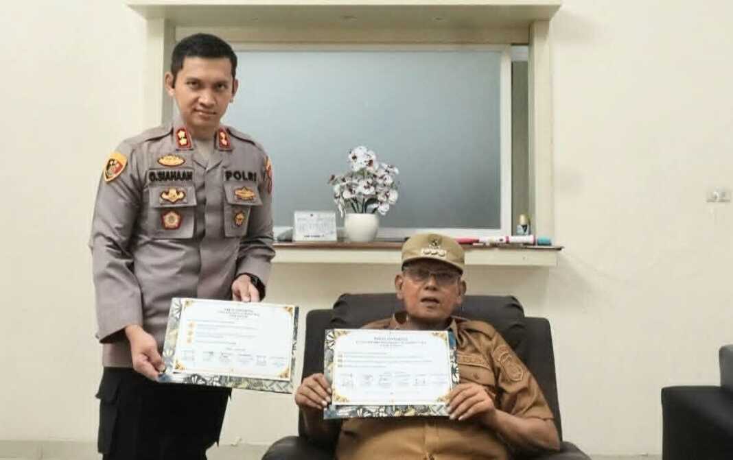 Bupati Dairi Vickner Sinaga dan Kapolres AKBP Otniel Siahaan menunjukkan naskah fakta integritas usai lakukan penandatanganan, Senin (26/10).(dok.RUDY SIANGGANG/SUMUT POS).