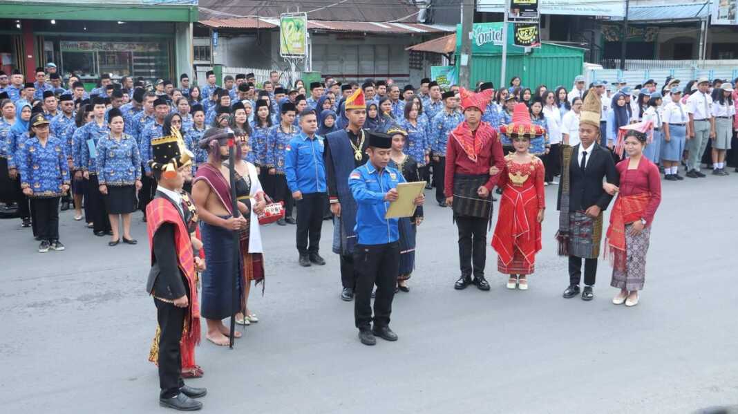 Salah seorang pemuda dari Komite Nasional Pemuda Indonesias (KNPI) didampingi perwakilan Pemuda dengan mengenakan pakaian adat dari berbagai suku di Dairi dalam kegiatan sumpah pemuda.