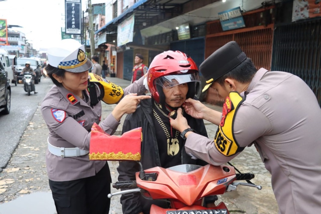 Kapolres Dairi AKBP Otniel Siahaan dan Kasat Lantas Iptu Rotua Sipayung memberikan helm secara gratis kepada pengendara saat pantau Operasi Patuh Toba 2026 di Sidikalang, Kamis (29/10). (dok.RUDY SITANGGANG/SUMUT POS.